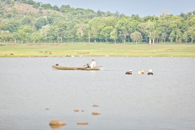 Người dân bơi thuyền gỗ mưu sinh trên hồ Ea Kao